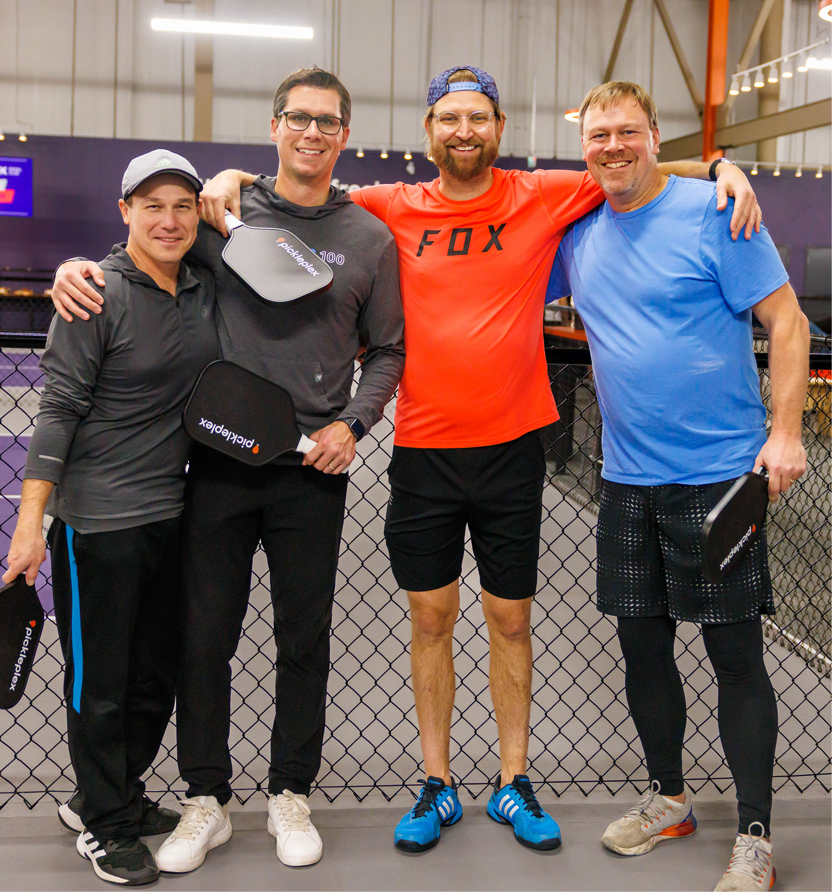 beginners on court, coach with small group, bright room.
